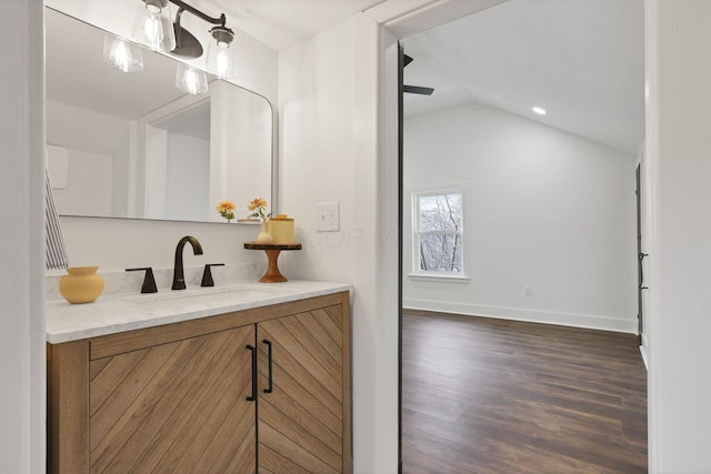 bathroom featuring vanity, wood-type flooring, and lofted ceiling