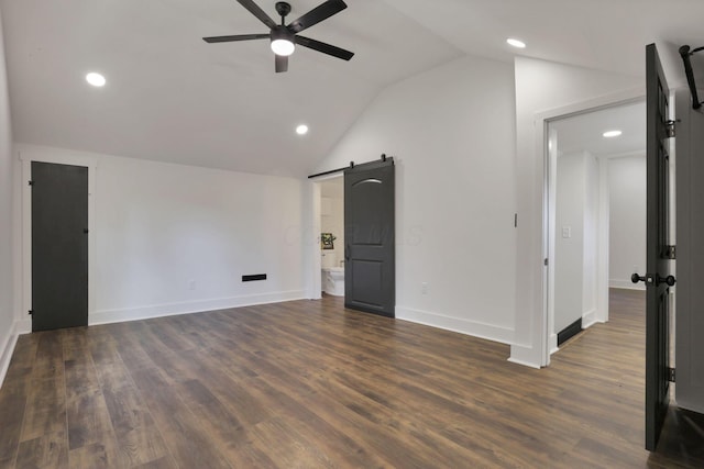 interior space featuring ceiling fan, a barn door, dark hardwood / wood-style flooring, and lofted ceiling