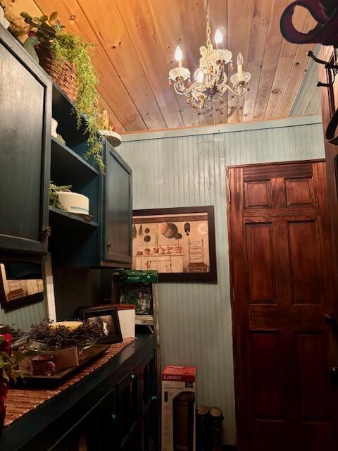 interior space featuring wood walls, wood ceiling, and a notable chandelier