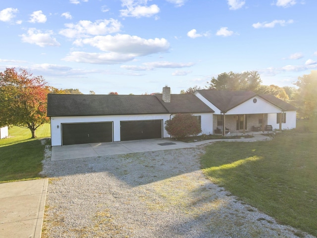 view of front of property with a garage, covered porch, and a front yard