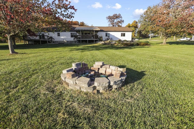 view of yard featuring a deck and an outdoor fire pit