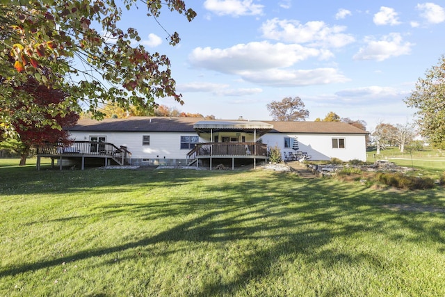 back of house featuring a wooden deck and a yard