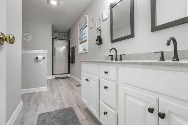 bathroom featuring hardwood / wood-style flooring, vanity, and an enclosed shower