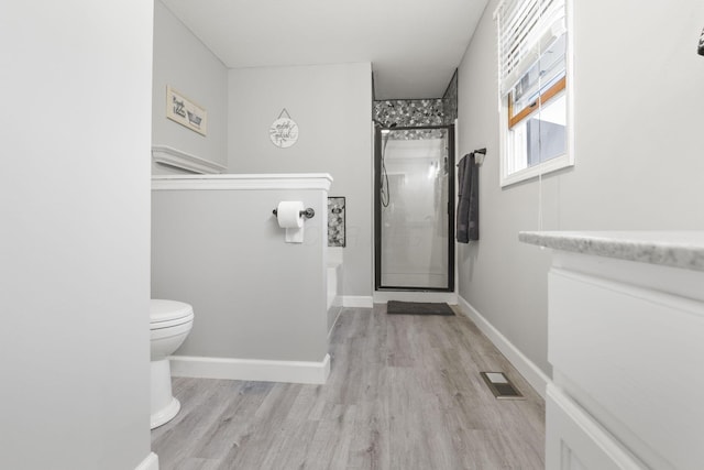 bathroom featuring hardwood / wood-style floors, toilet, and walk in shower