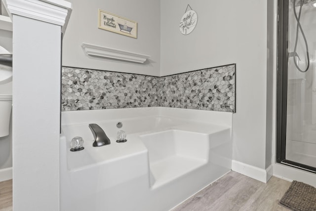 bathroom with hardwood / wood-style floors and a shower with shower door