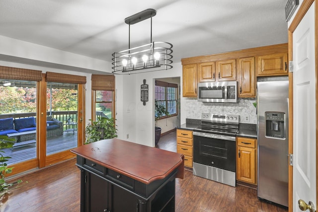 kitchen with hanging light fixtures, dark wood-type flooring, stainless steel appliances, an inviting chandelier, and backsplash