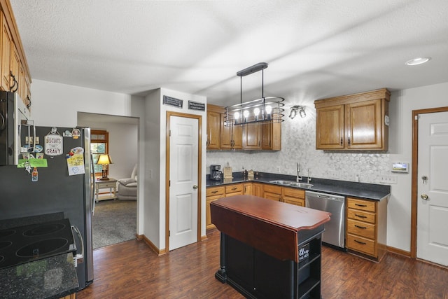 kitchen with sink, hanging light fixtures, stainless steel appliances, dark wood-type flooring, and tasteful backsplash