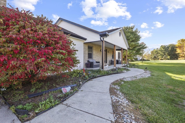 view of home's exterior featuring covered porch and a yard