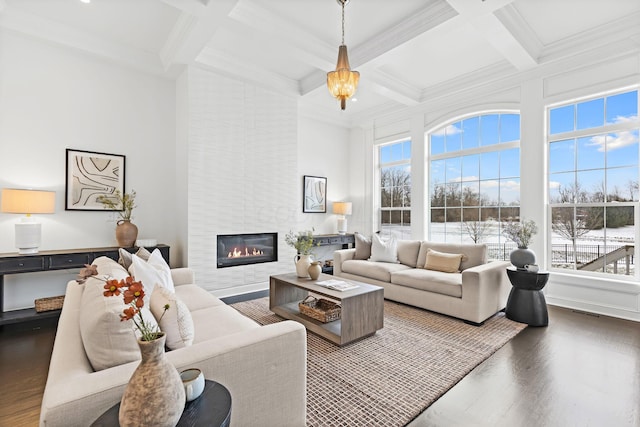 living room with beamed ceiling, a large fireplace, coffered ceiling, crown molding, and dark wood-type flooring