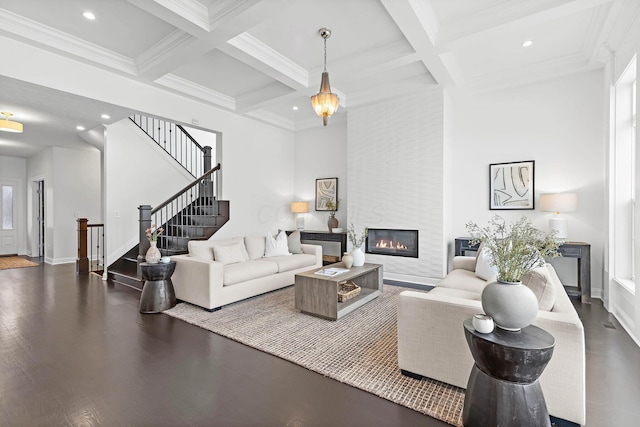 living room with coffered ceiling, a large fireplace, and beam ceiling