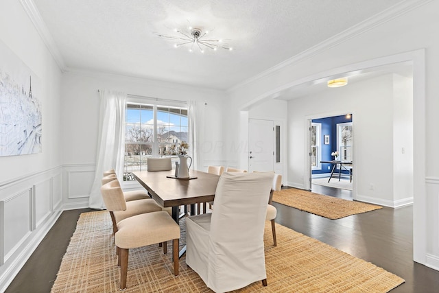 dining room featuring ornamental molding, dark hardwood / wood-style floors, a chandelier, and a textured ceiling