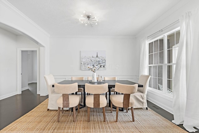 dining area featuring crown molding, wood-type flooring, and a chandelier