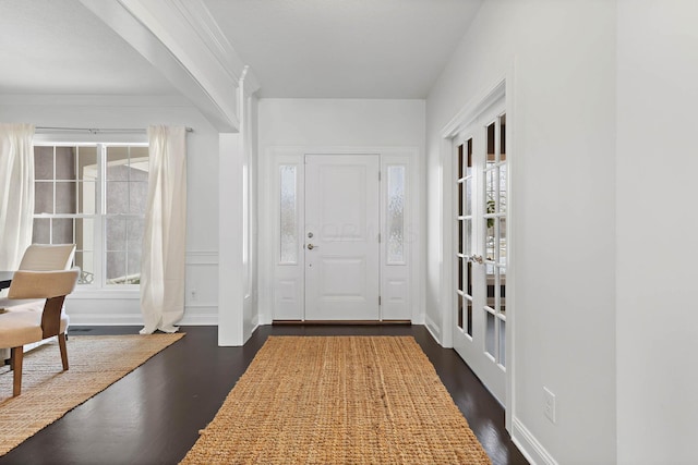 entrance foyer with dark hardwood / wood-style flooring, ornamental molding, and french doors