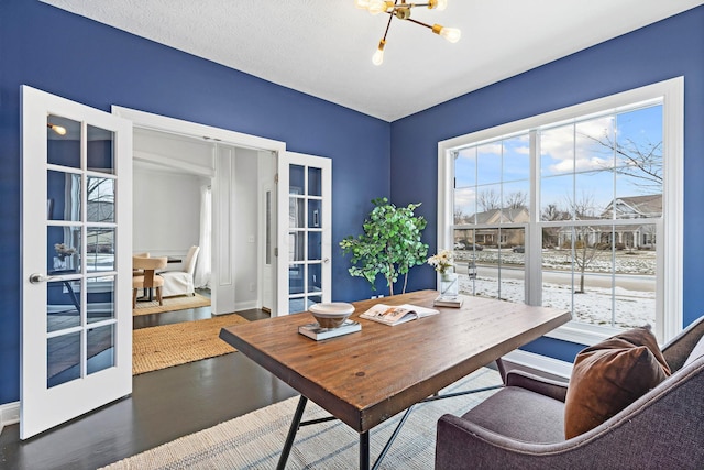 dining area featuring hardwood / wood-style floors, french doors, and a chandelier