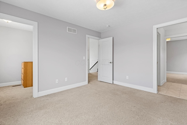 unfurnished bedroom with light colored carpet