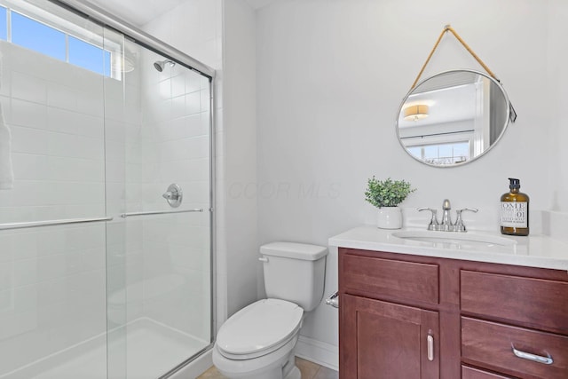 bathroom with walk in shower, vanity, and toilet