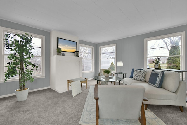 carpeted living room with a wealth of natural light and crown molding