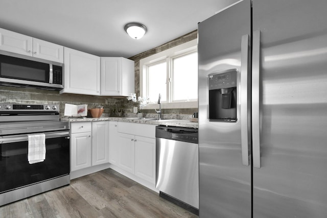 kitchen featuring white cabinets, light stone counters, sink, and stainless steel appliances