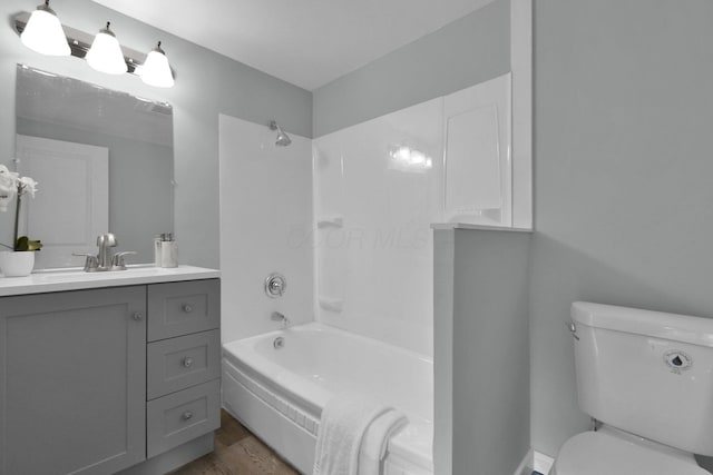 full bathroom with hardwood / wood-style floors, vanity, toilet, and washtub / shower combination