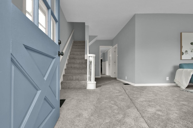 foyer entrance featuring carpet floors