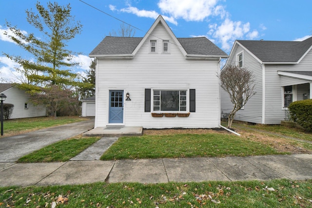 view of front facade featuring an outbuilding, a front lawn, and a garage