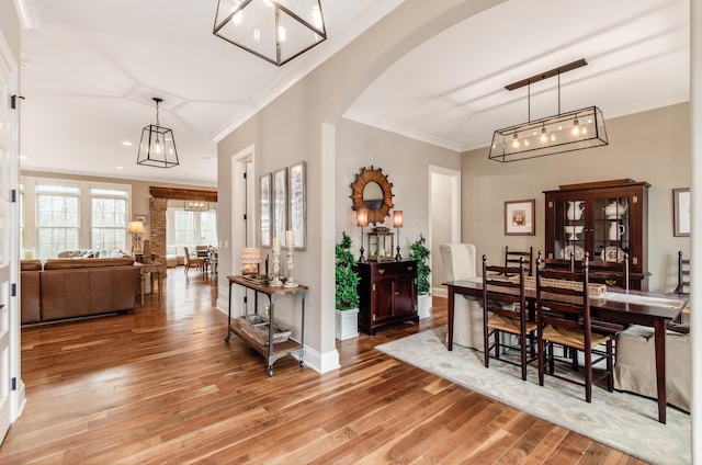 dining space with light hardwood / wood-style floors and ornamental molding