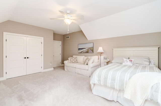 carpeted bedroom with ceiling fan, a closet, and vaulted ceiling