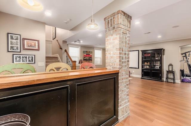 interior space with light hardwood / wood-style flooring, pendant lighting, and wood counters