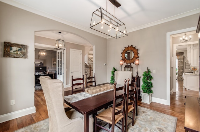 dining area with crown molding and light hardwood / wood-style flooring