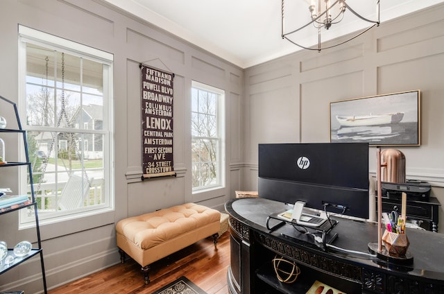 office area featuring hardwood / wood-style floors, crown molding, and a notable chandelier