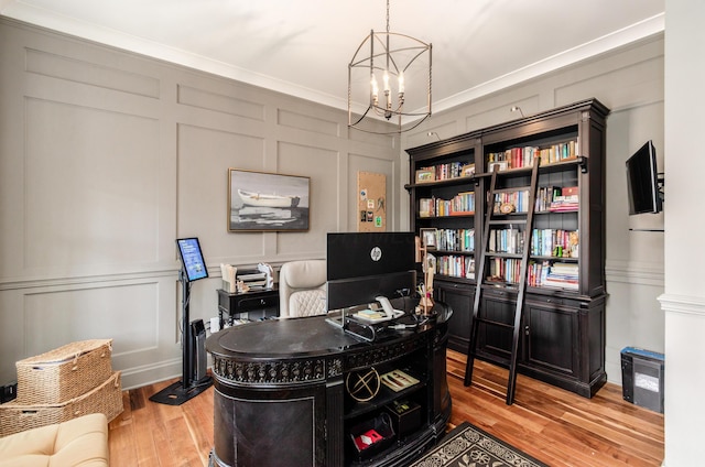 office area with wood-type flooring, a notable chandelier, and ornamental molding