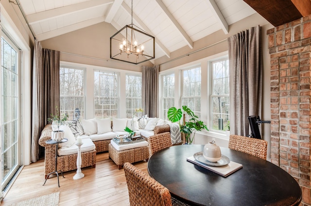 sunroom featuring lofted ceiling with beams and an inviting chandelier