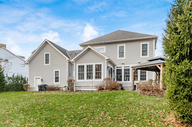 rear view of property with a gazebo and a yard