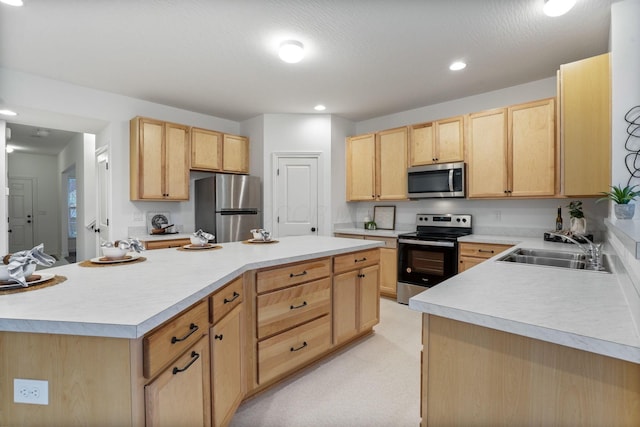 kitchen featuring a center island, sink, stainless steel appliances, and light brown cabinets