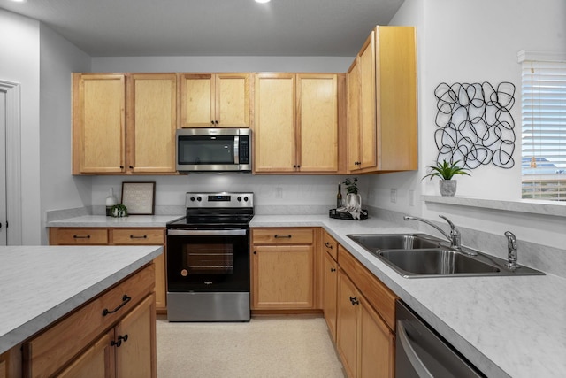 kitchen featuring appliances with stainless steel finishes, light brown cabinets, and sink