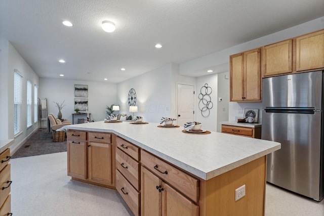 kitchen with a center island, a textured ceiling, and stainless steel refrigerator