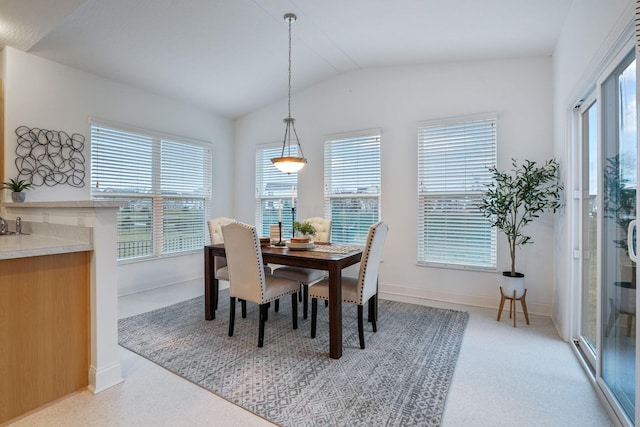 dining area featuring light carpet, vaulted ceiling, and a wealth of natural light