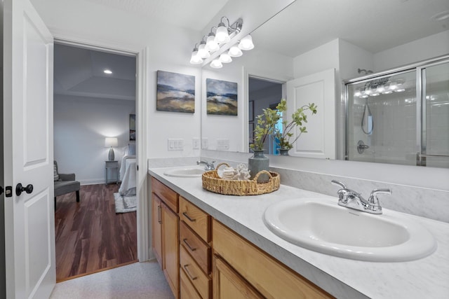 bathroom featuring hardwood / wood-style flooring, vanity, and an enclosed shower