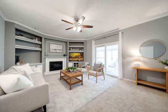 carpeted living room with built in shelves, a textured ceiling, ceiling fan, and crown molding