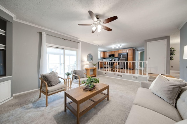 carpeted living room with ceiling fan, a textured ceiling, and ornamental molding