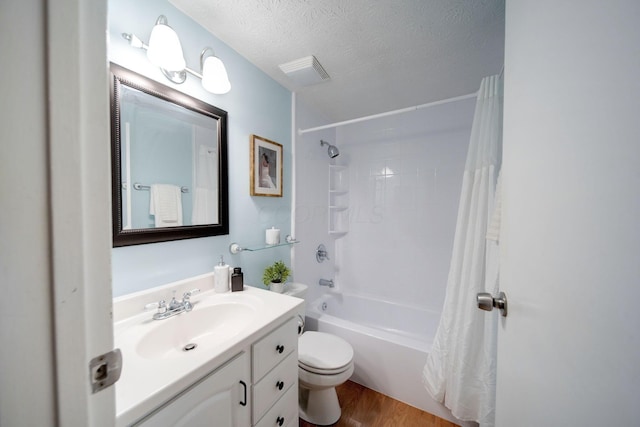 full bathroom with vanity, toilet, a textured ceiling, wood-type flooring, and shower / tub combo