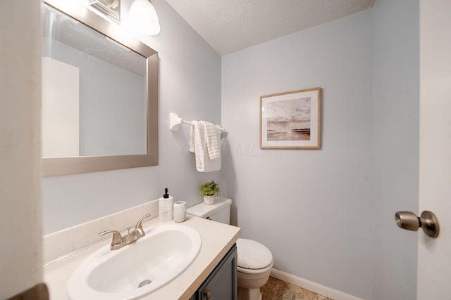 bathroom featuring vanity, a textured ceiling, and toilet