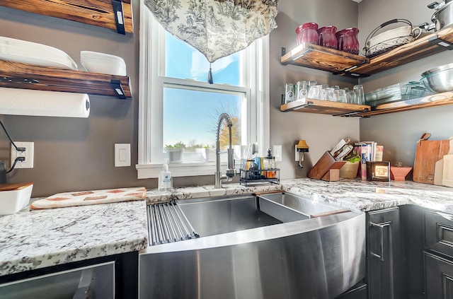 kitchen featuring light stone counters, sink, and wine cooler