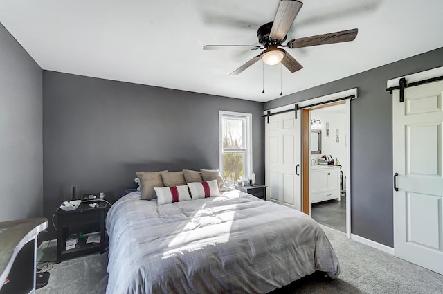 bedroom featuring ceiling fan, a barn door, and dark carpet