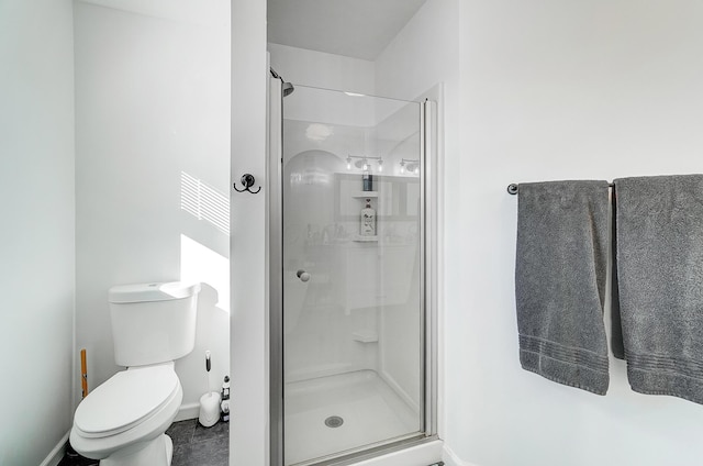 bathroom featuring tile patterned flooring, toilet, and an enclosed shower