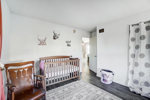 bedroom featuring a crib and hardwood / wood-style flooring