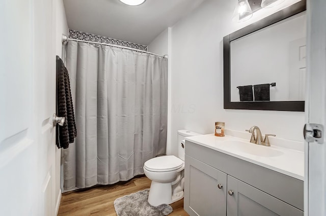 bathroom with vanity, hardwood / wood-style flooring, toilet, and curtained shower