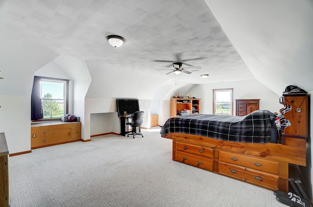 carpeted bedroom featuring multiple windows, ceiling fan, and lofted ceiling