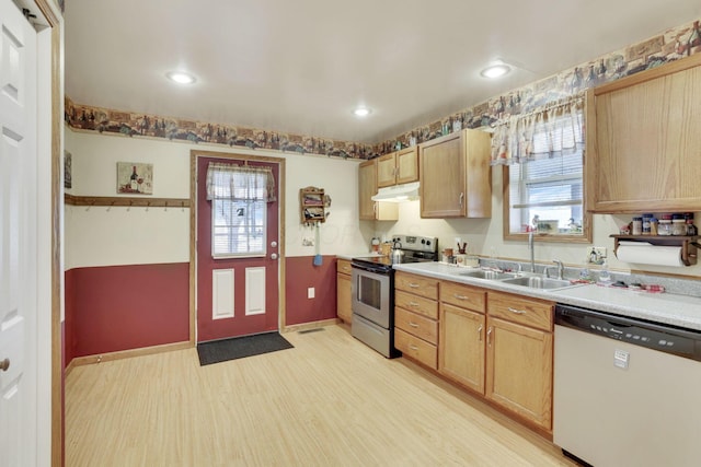 kitchen featuring under cabinet range hood, a sink, stainless steel range with electric cooktop, dishwasher, and light wood finished floors