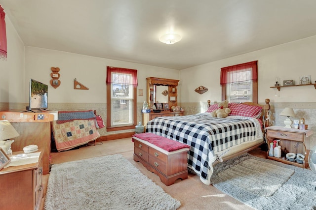 bedroom with carpet floors, multiple windows, and wainscoting